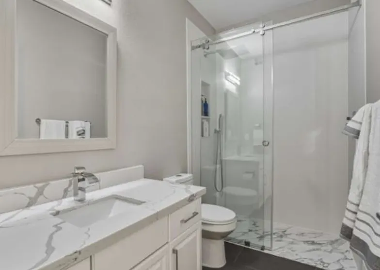 Remodeled white bathroom with glass shower